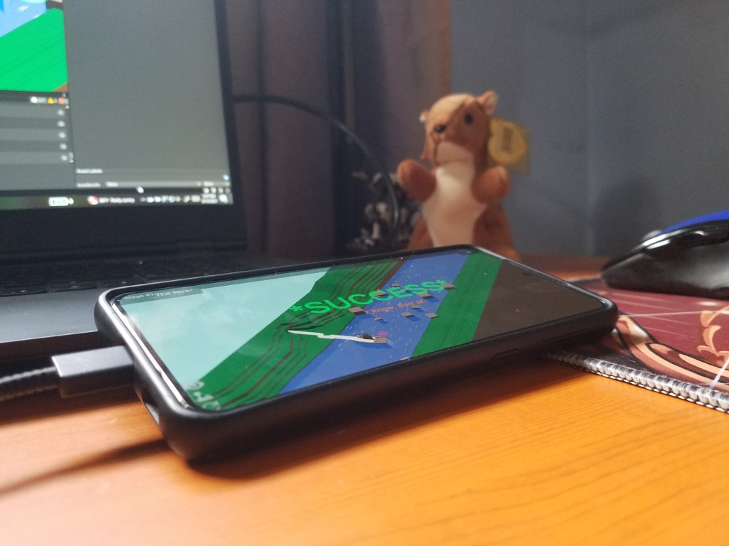 Riverboat Pachinko running on a phone, in front of Nuts, the beanie baby squirrel. Nuts says hi.