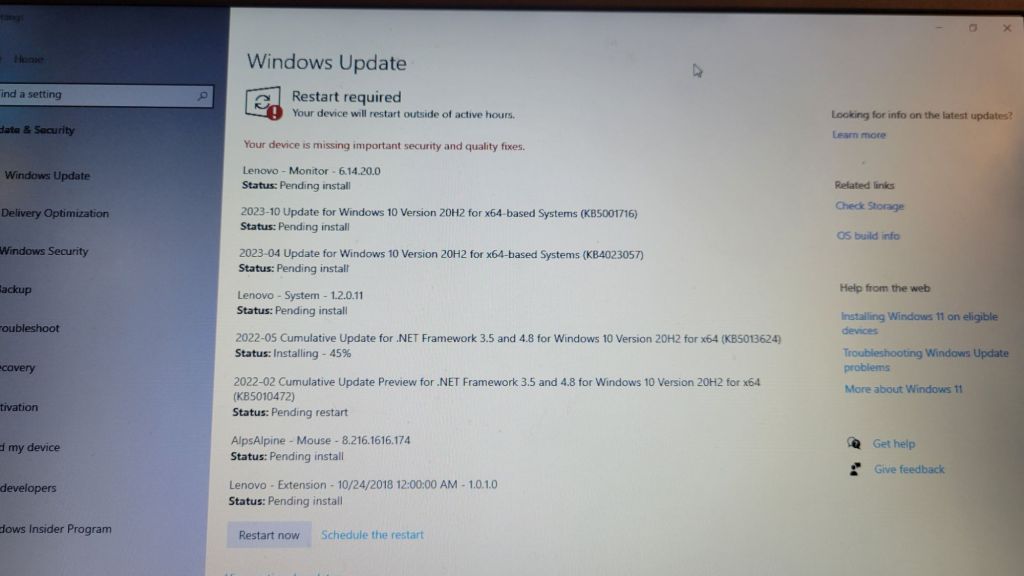 The windows 10 update screen, captured on a phone camera. About 6 pending installs, 1 in progress, 1 pending restart.
