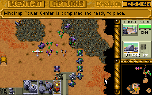 A top-down view of Dune II's desert, with small gray vehicles trawling over the 16-bit sands.